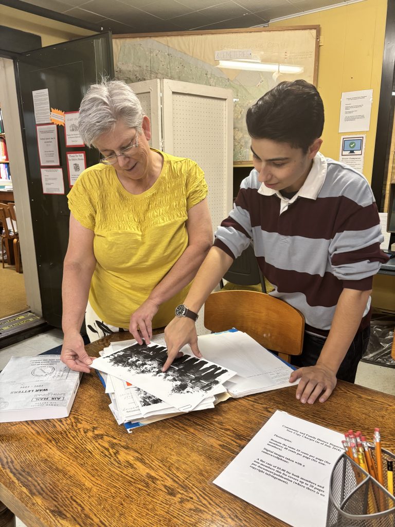 Two people look at records from the Kings County Museum's archives.